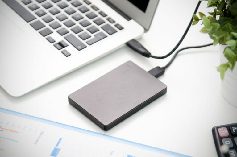 External backup disk hard drive connected to laptop.