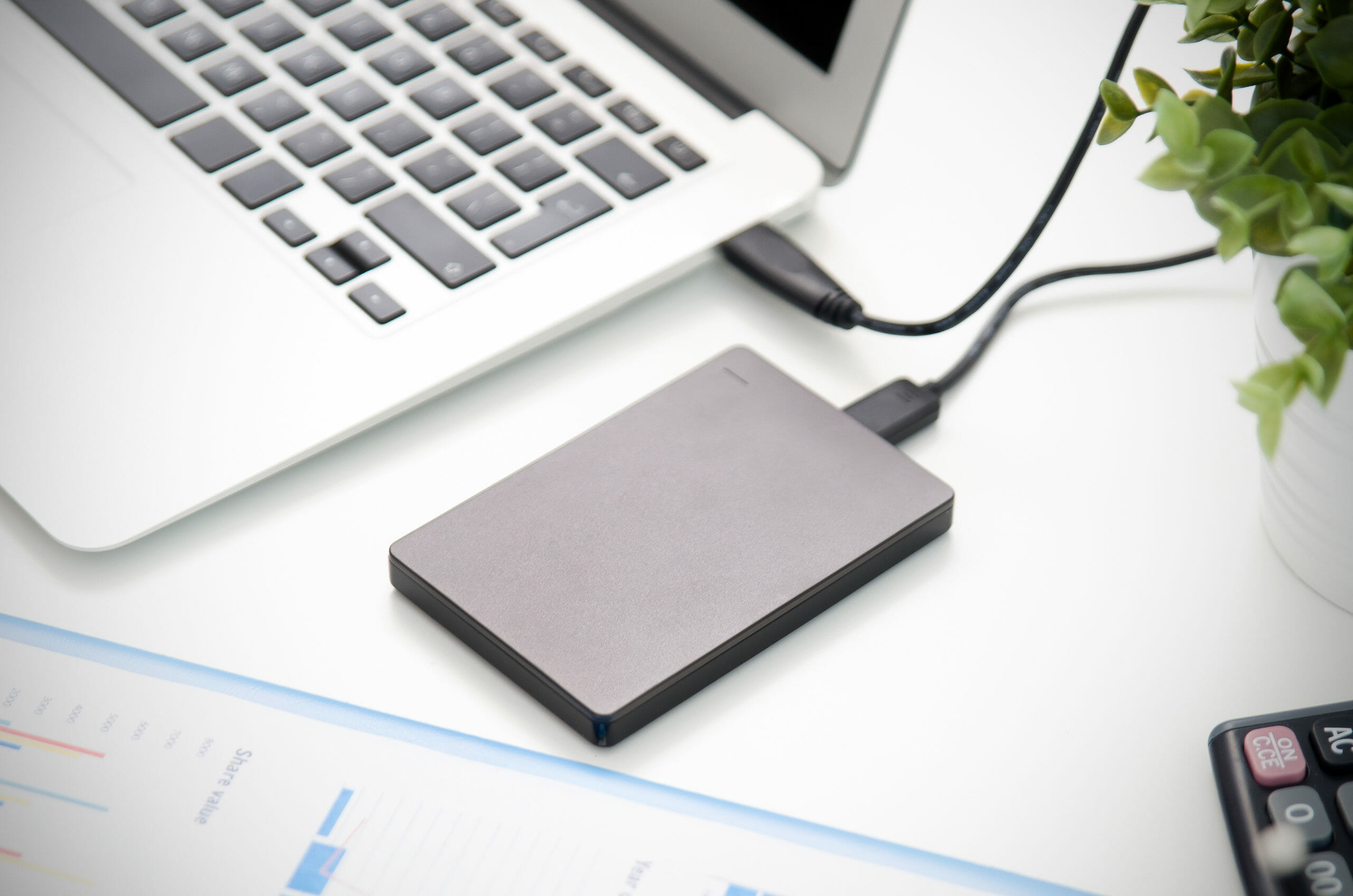 External backup disk hard drive connected to laptop.
